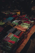 Close-up of colorful handmade pet clothes laid out on a vibrant fabric background.