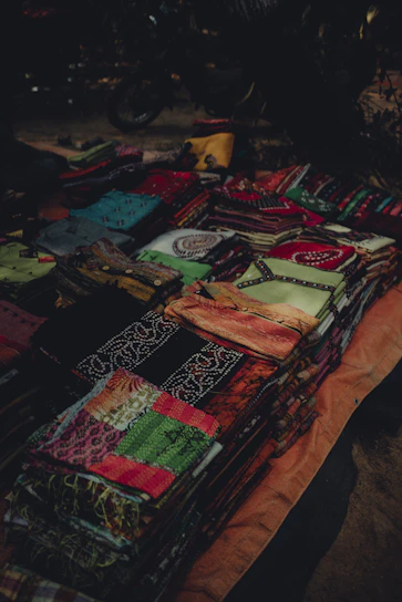 A vibrant display of colorful folded fabrics stacked neatly in natural light.