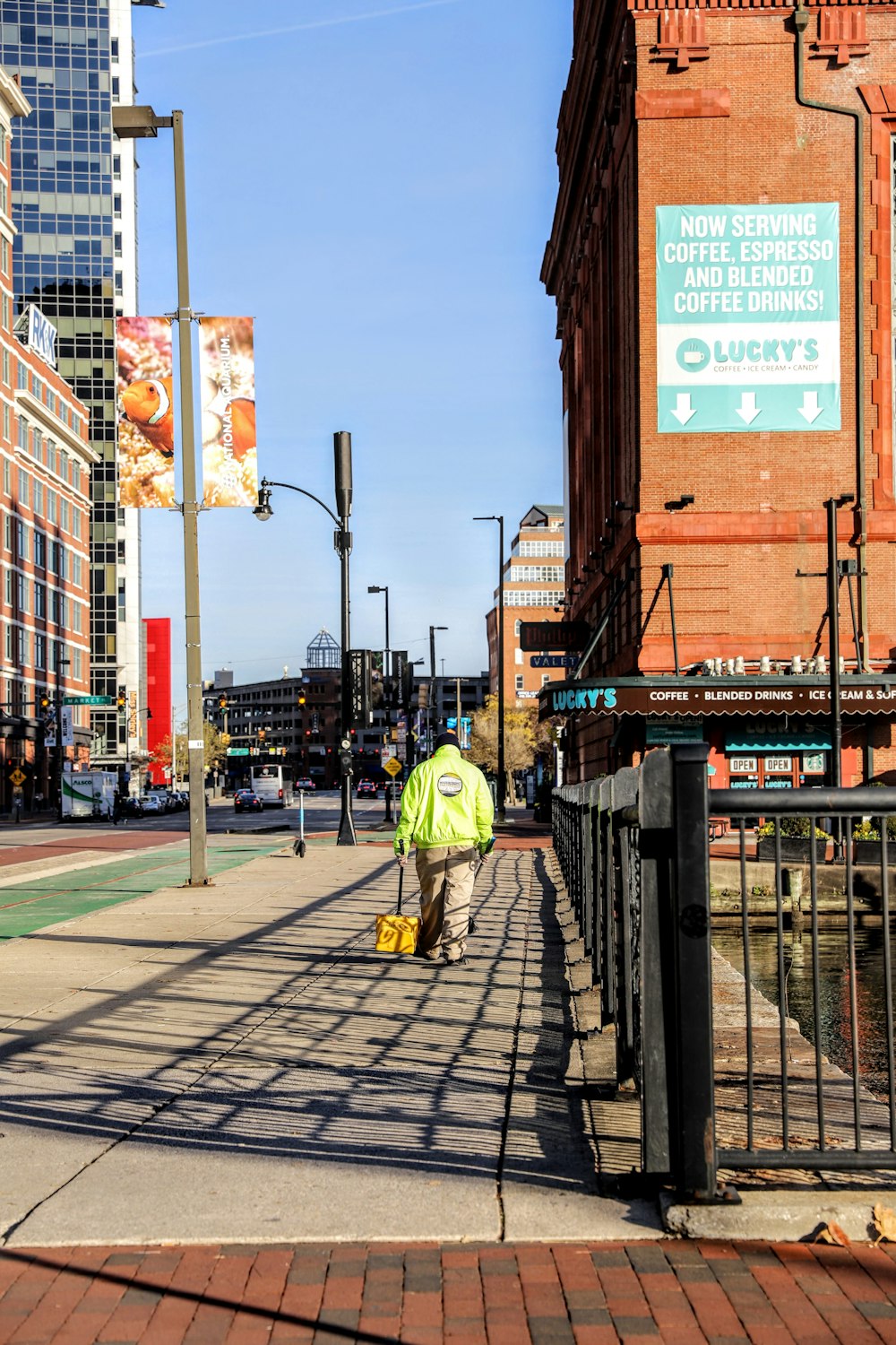 a man in a yellow jacket is walking down the street