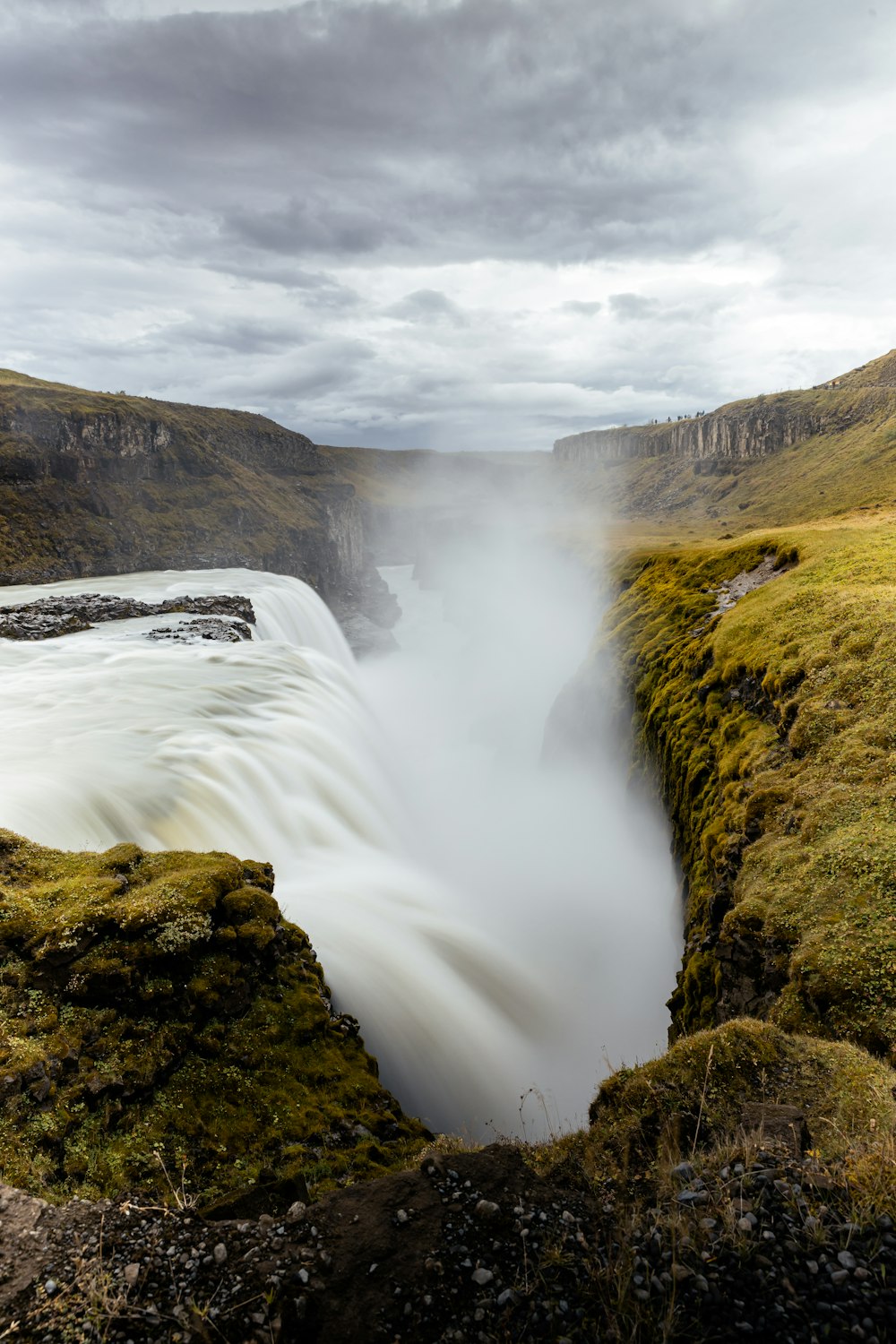 una gran masa de agua rodeada por una exuberante ladera verde