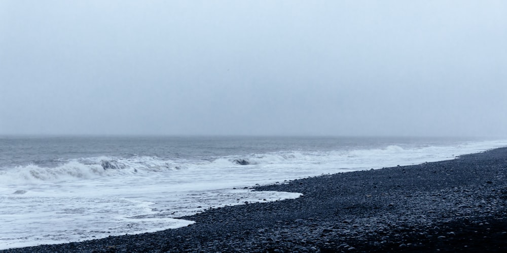 a person walking on a beach with a surfboard