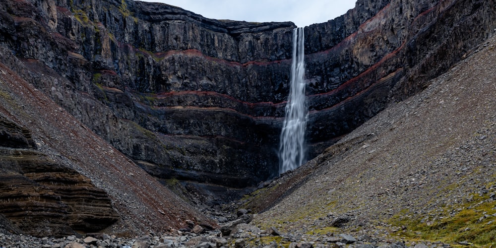 a waterfall is coming out of the side of a mountain