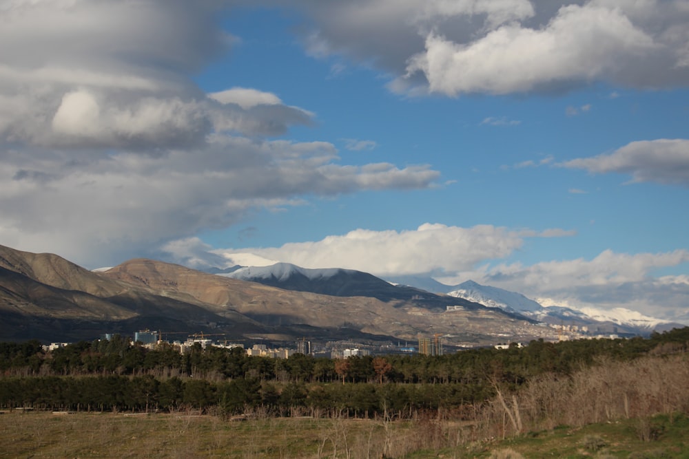 a view of a city in the distance with mountains in the background