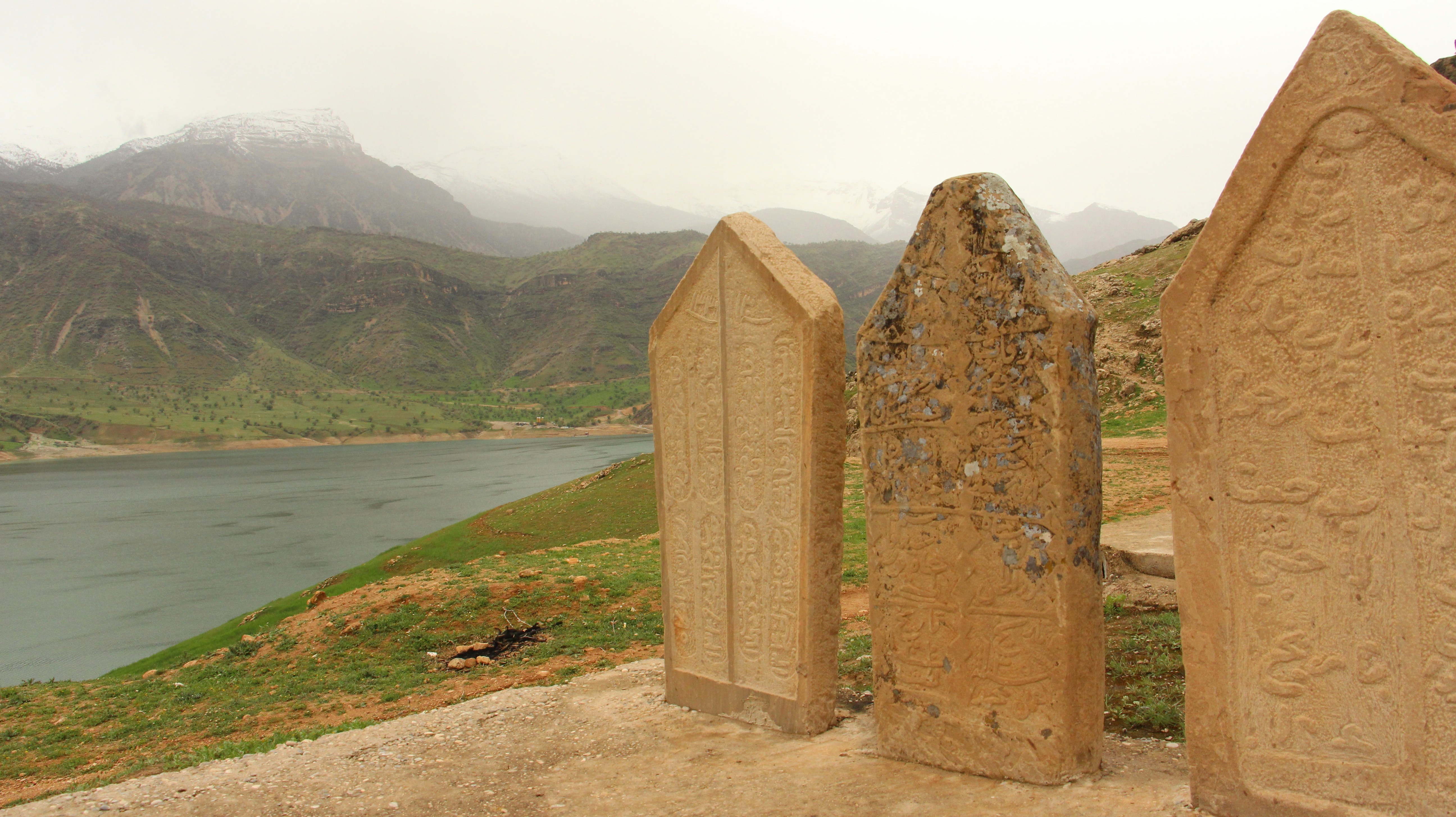 a group of tombstones sitting on top of a dirt field
