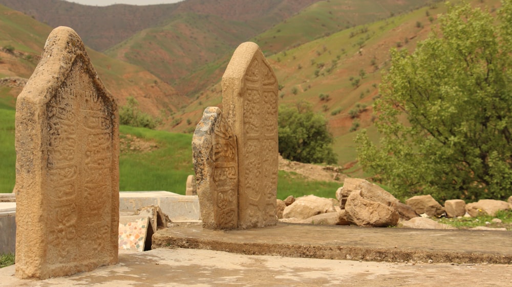 a couple of stone sculptures sitting on top of a cement slab