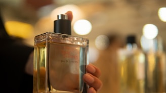 Close-up of a master perfumer carefully blending scents in a sunlit workshop filled with glass bottles and natural ingredients.
