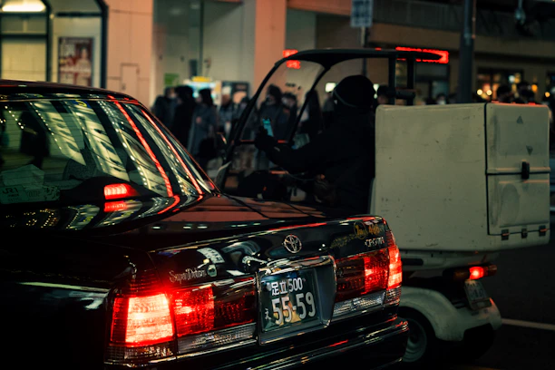A modern delivery van navigating through a bustling African city street at sunset.