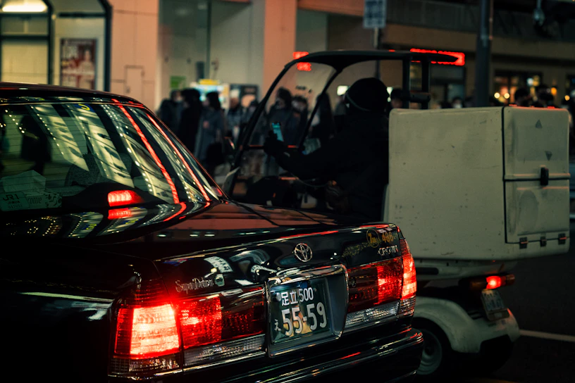 A sleek delivery truck equipped with advanced GPS and IoT devices driving through a cityscape at dusk.