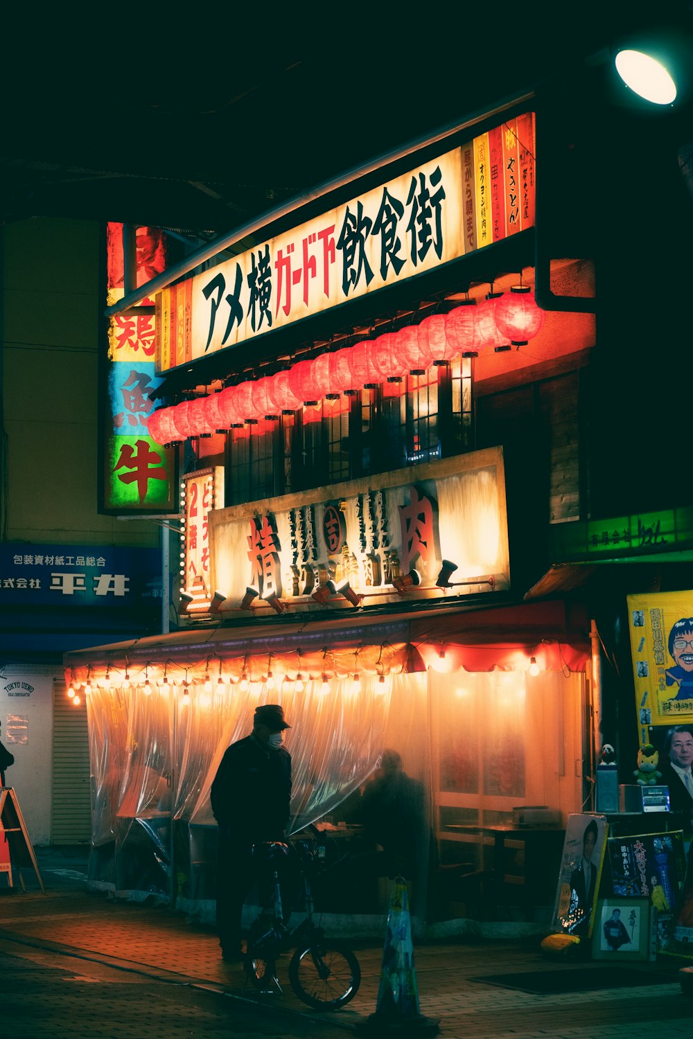 a man riding a bike down a street next to a tall building