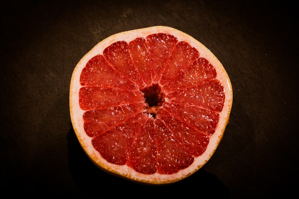 Eine in zwei Hälften geschnittene Grapefruit sitzt auf einem Tisch