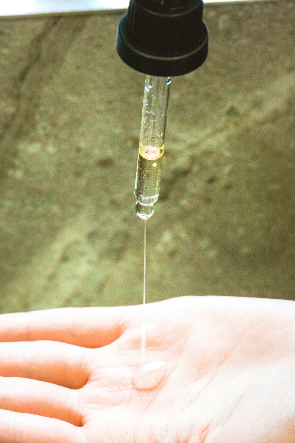 a person is holding a small pipe with a liquid coming out of it