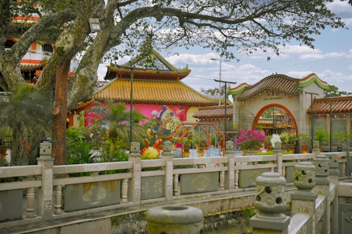 Traditional Asian temple surrounded by lush greenery and colorful lanterns