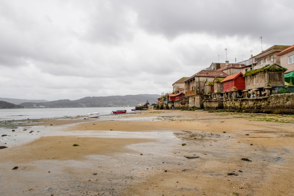 a row of houses sitting on top of a sandy beach