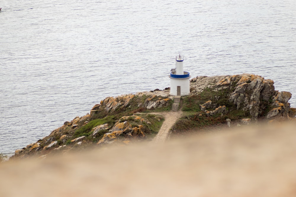 a lighthouse on a small island in the middle of the ocean