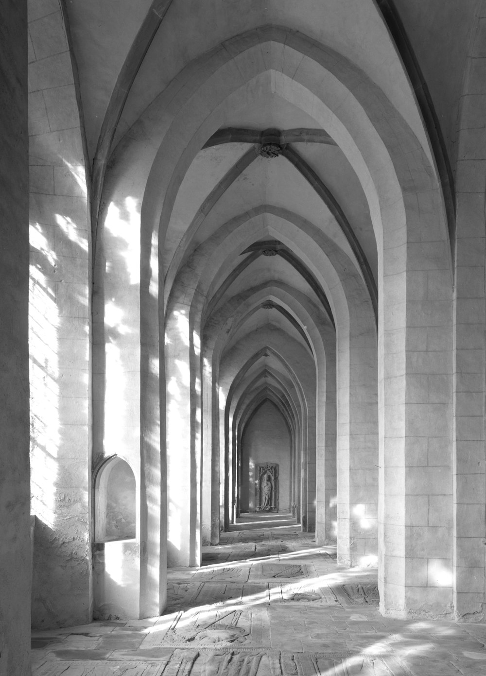 a black and white photo of a long hallway