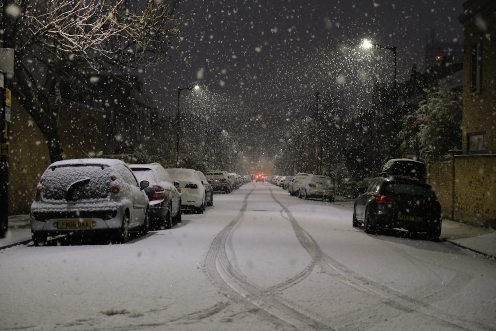 a snowy street with cars parked on the side of it