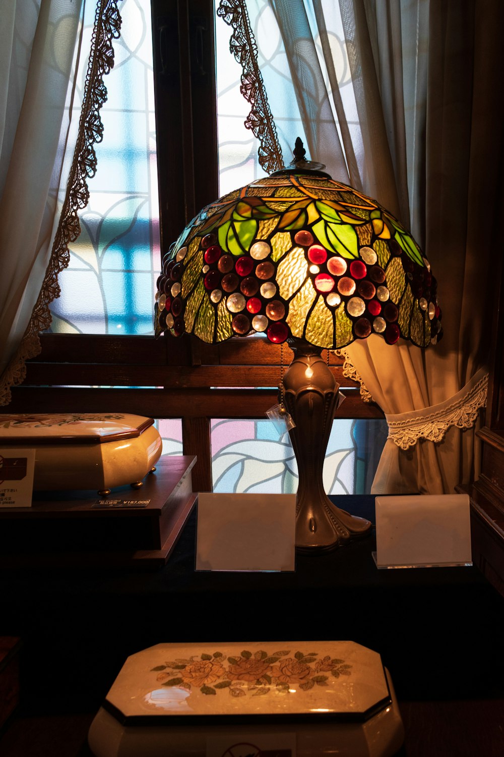 a lamp sitting on top of a table next to a window