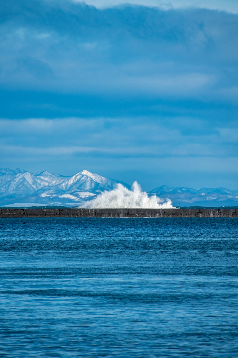 a large body of water with mountains in the background