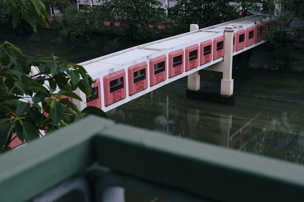 a red and white train traveling over a bridge