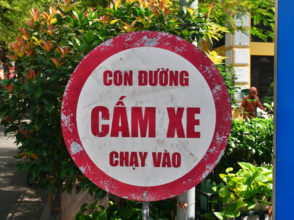 a red and white sign sitting on the side of a road