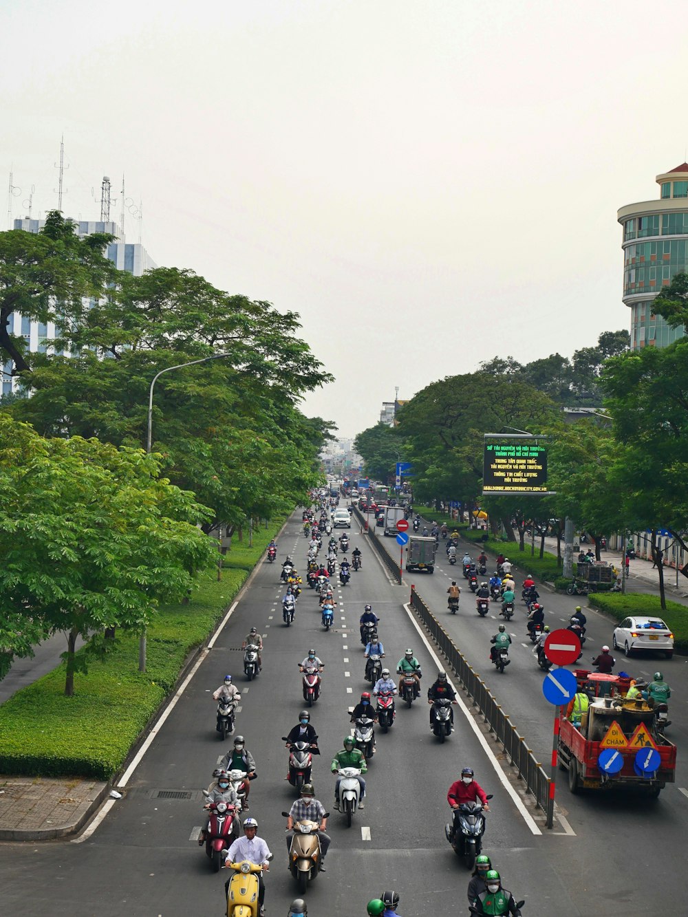 a large group of people riding motorcycles down a street