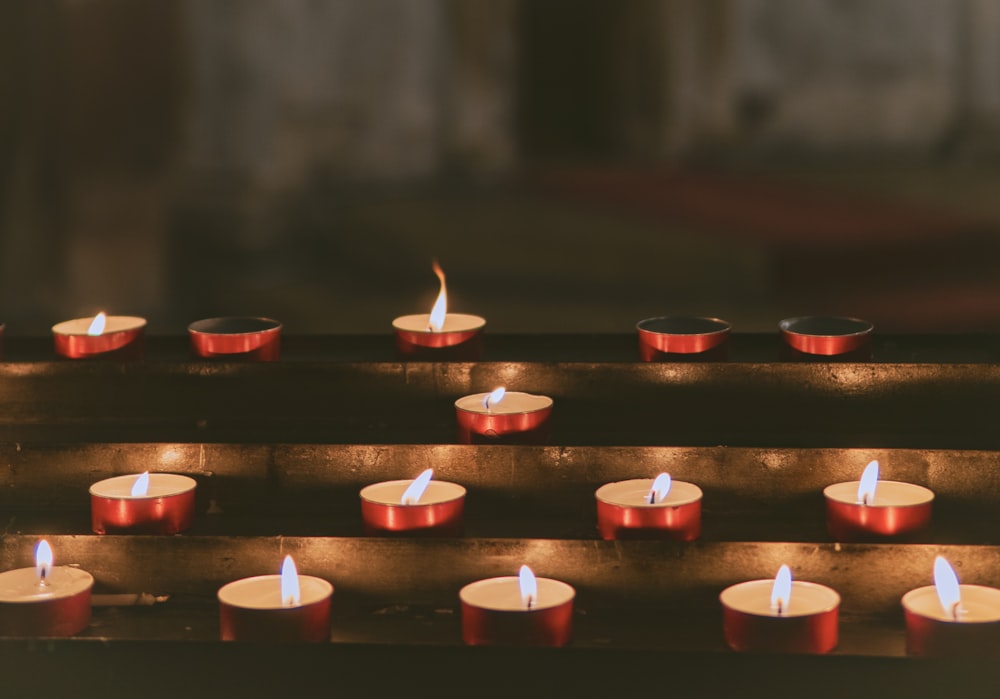 a row of lit candles sitting on top of a table