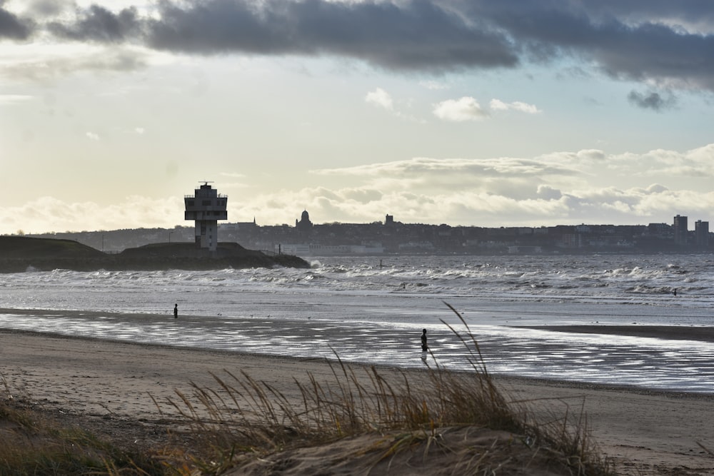 a view of a beach with a lighthouse in the distance