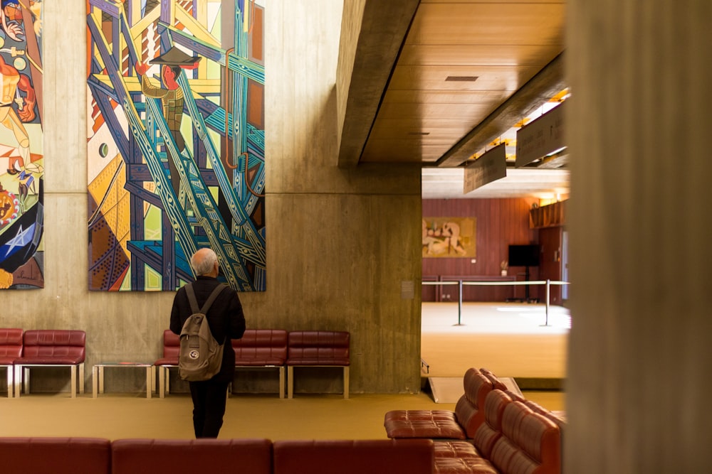 a person standing in front of a large painting