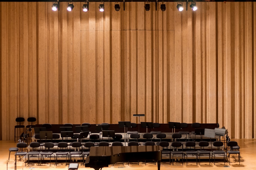a concert hall with rows of chairs and a piano