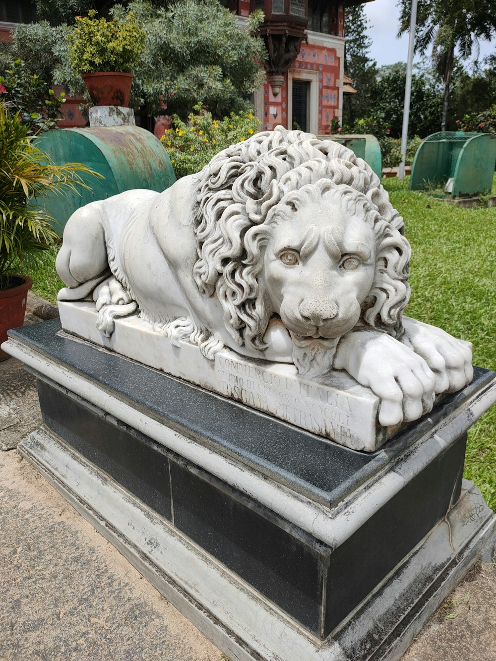a statue of a lion laying down in a garden
