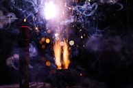 Bright, colorful sparks and smoke create a dramatic scene with vivid displays of light against a dark background. Glowing points of light and swirling smoke add a sense of movement and energy.