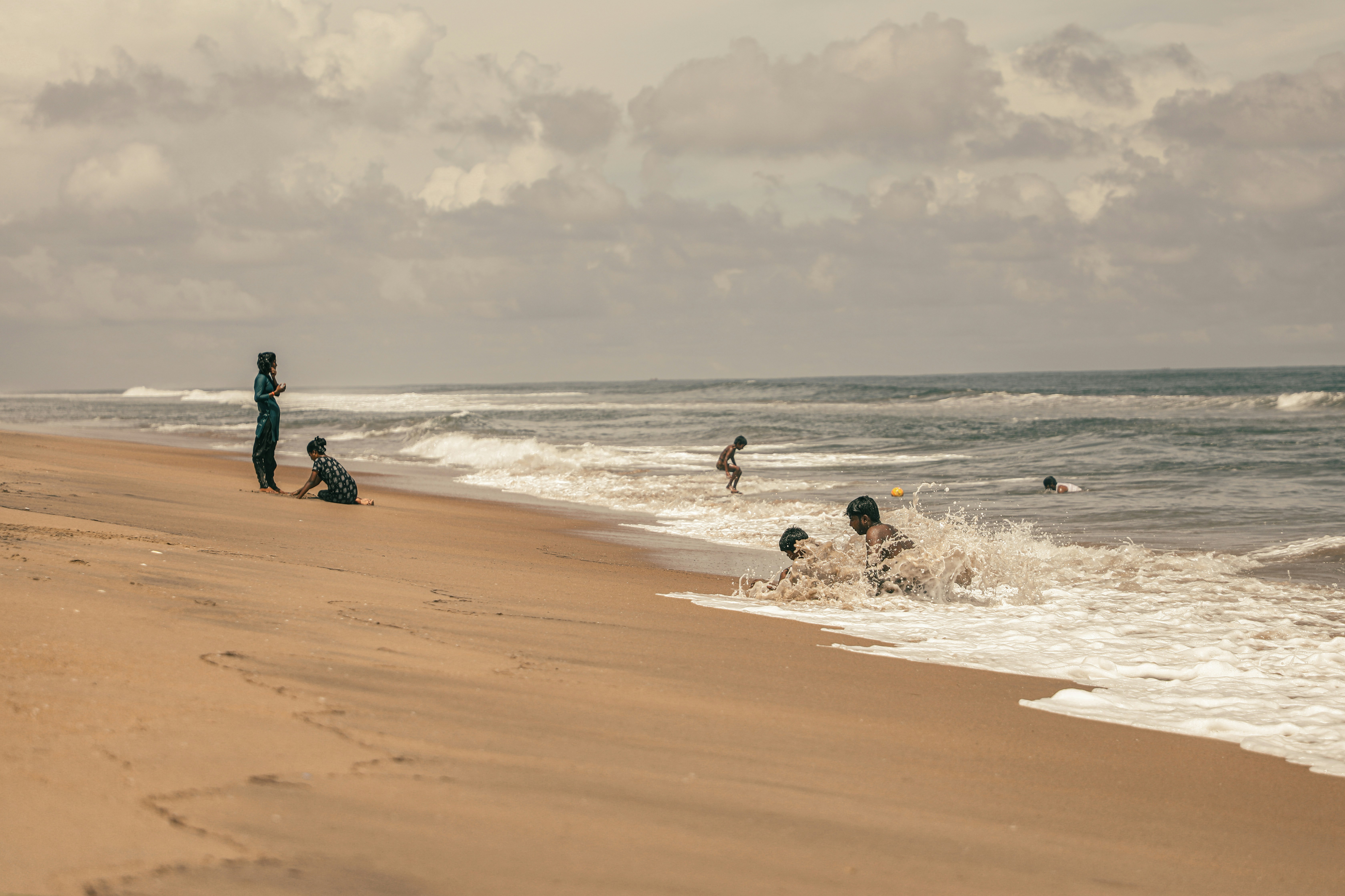 a group of people standing on top of a sandy beach