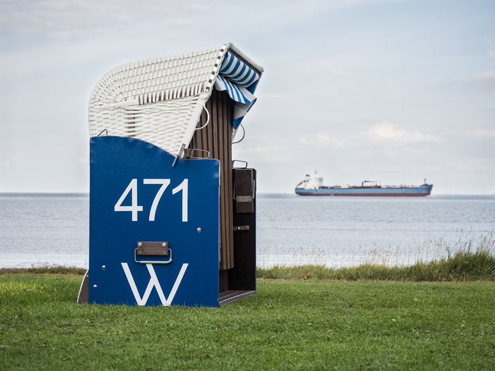 a blue and white sign sitting on top of a lush green field