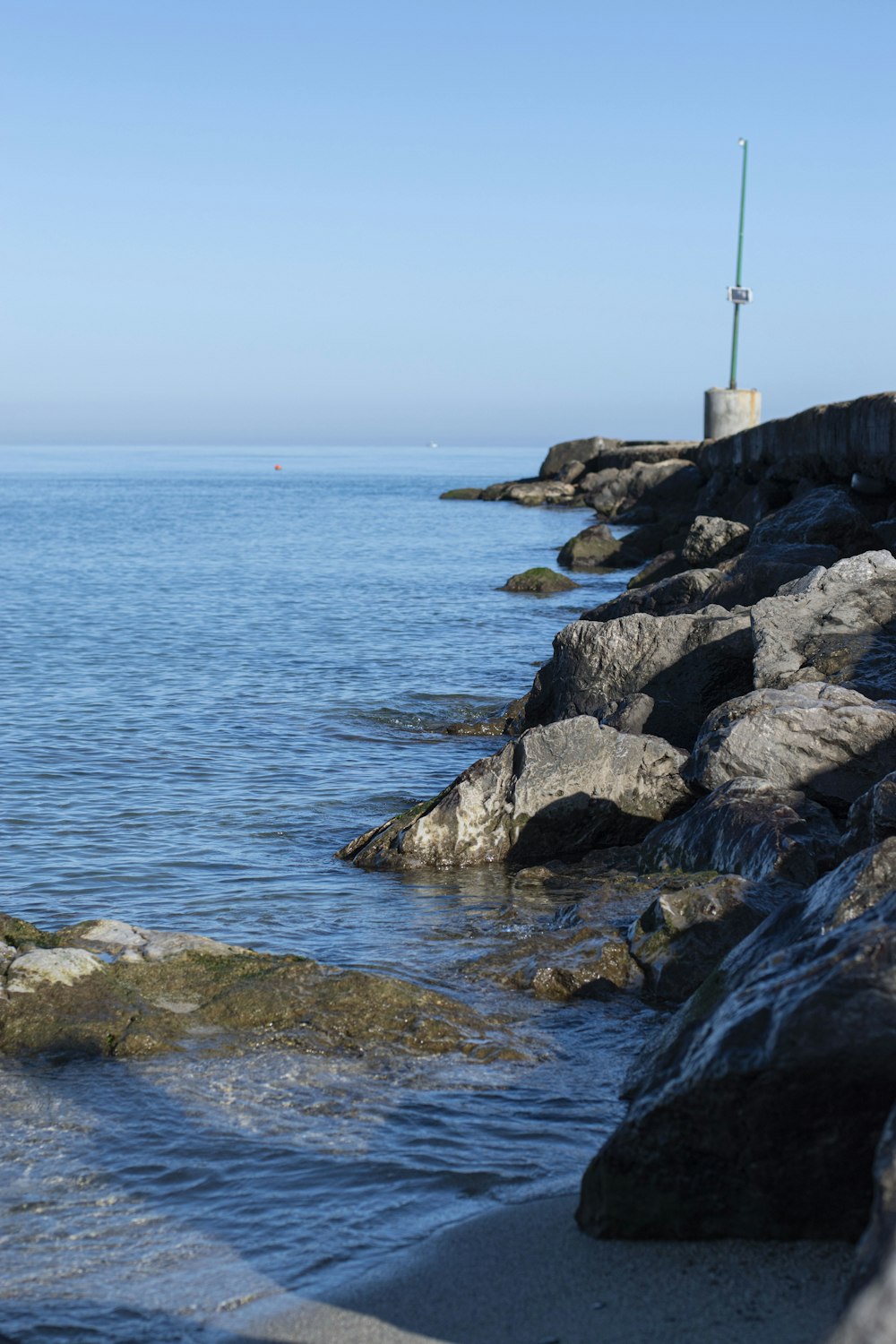 a view of a body of water from a rocky shore