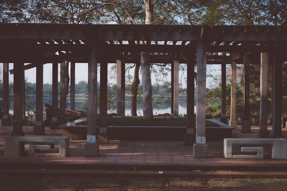 a gazebo with benches and trees in the background