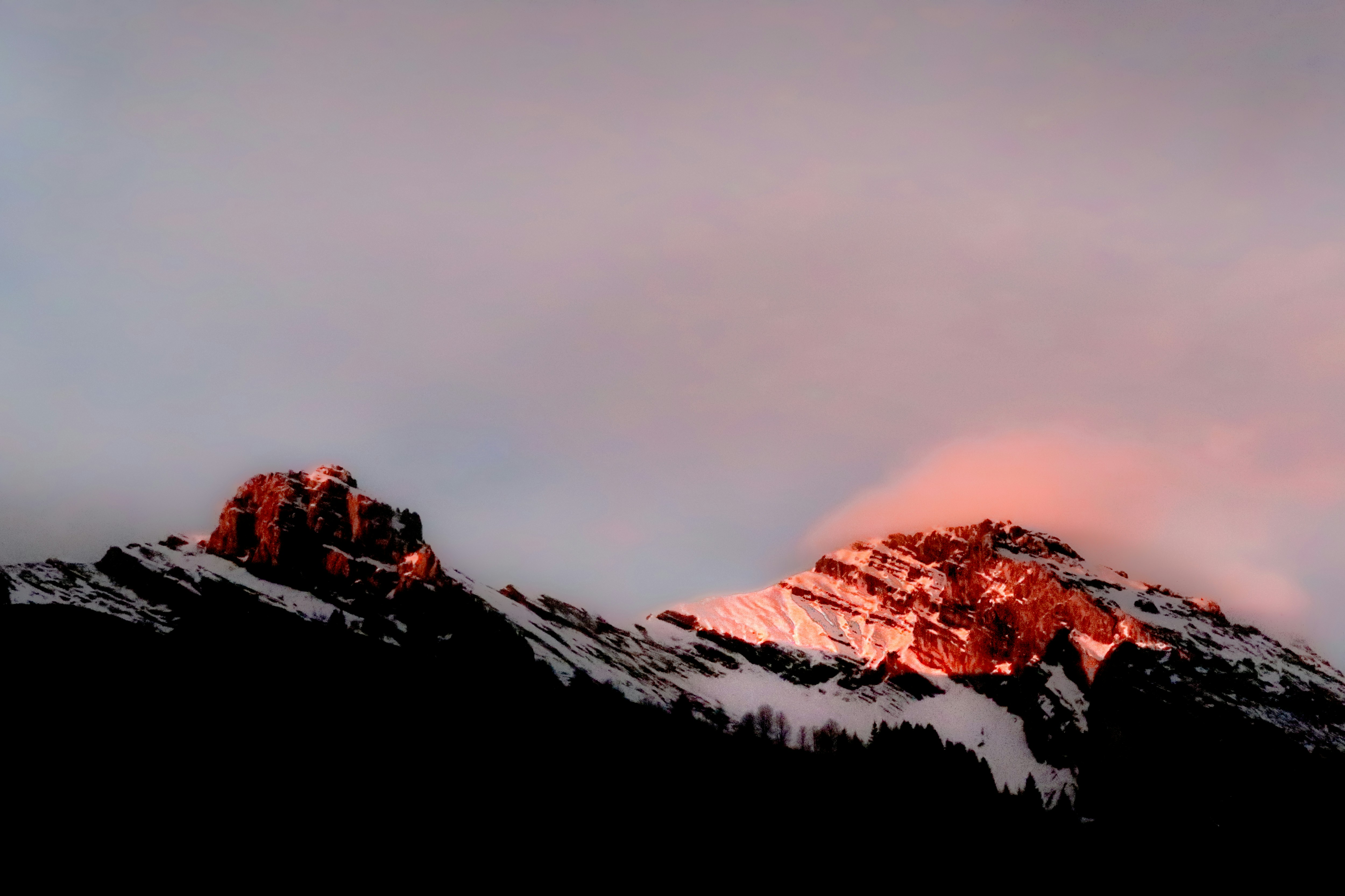 a snow covered mountain with a pink sky in the background