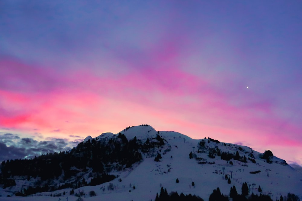 a mountain covered in snow under a purple sky