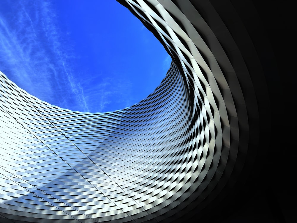 a curved building with a blue sky in the background