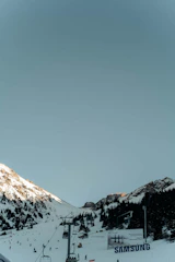 A scenic mountain resort with guests engaging in outdoor activities and digital screens showcasing promotions.