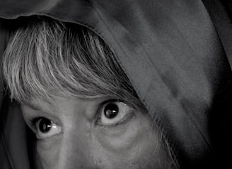 Close-up of intense eyes glowing under a dark hood.