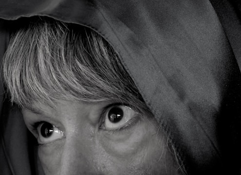 Close-up of intense eyes glowing under a dark hood.