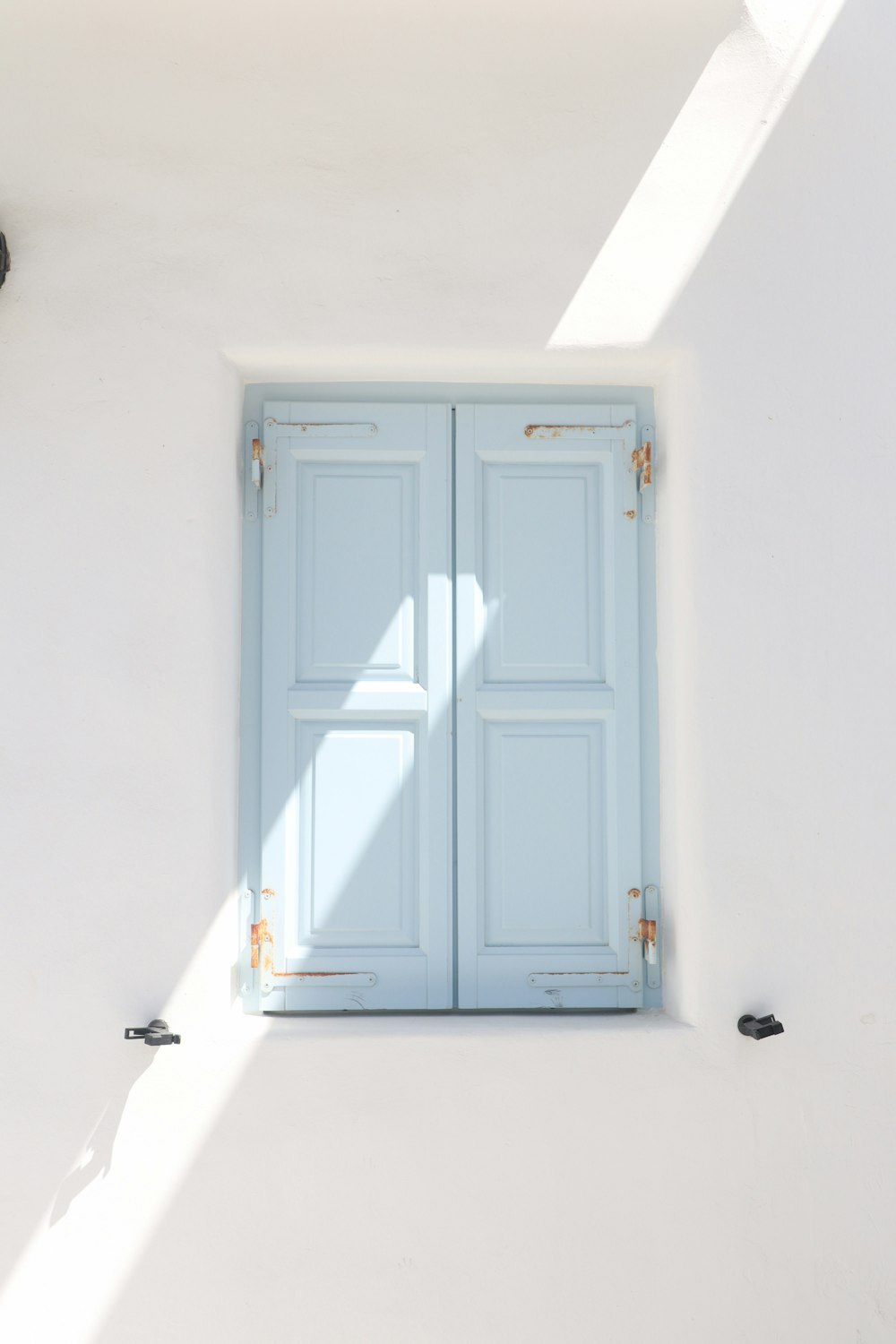 a white wall with a blue door and a window