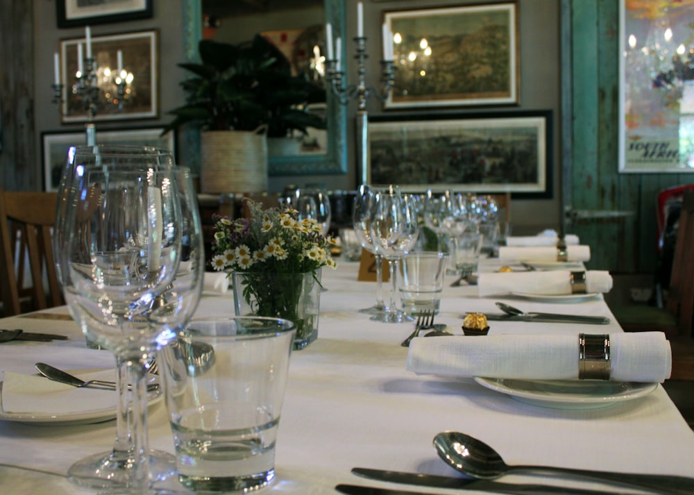 a table set for a formal dinner with silverware