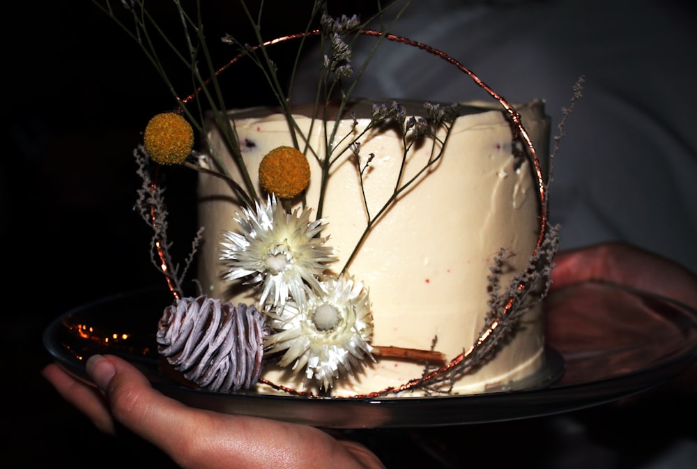 a person holding a plate with a cake on it