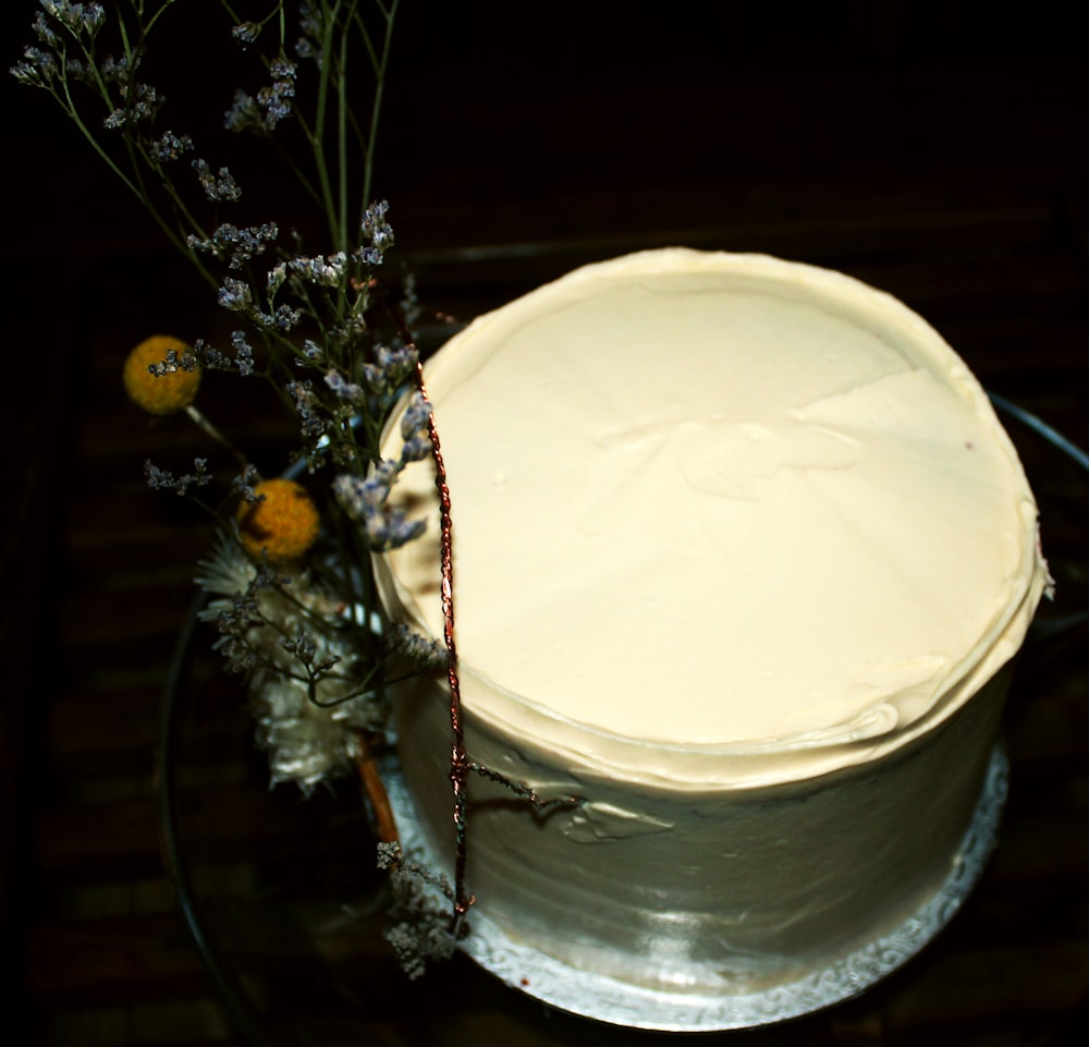 a white frosted cake sitting on top of a glass plate