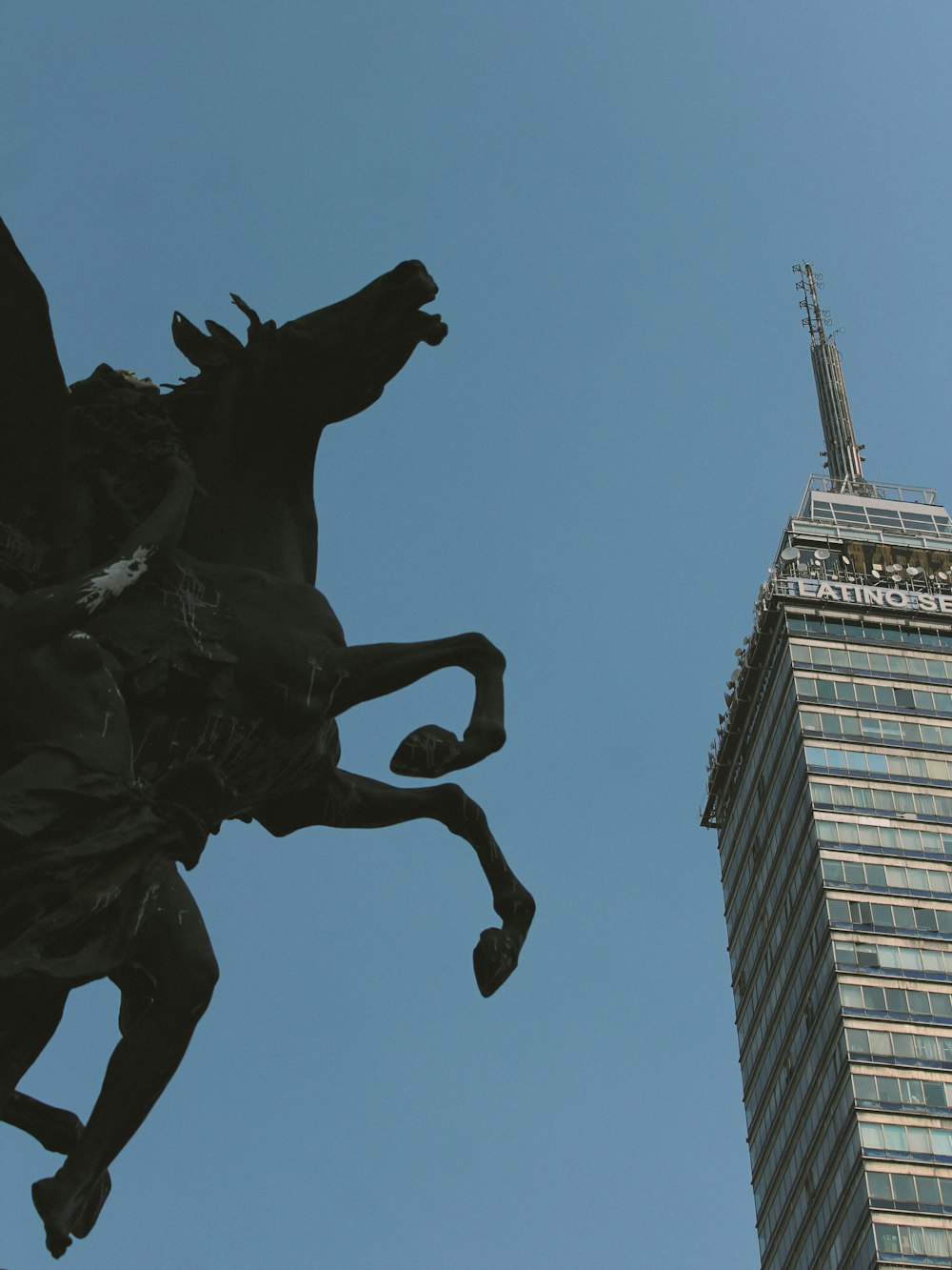 a statue of a man riding a horse next to a tall building