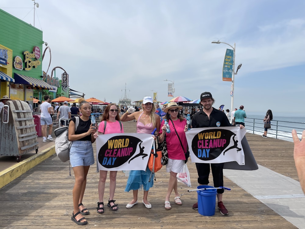 a group of people holding up signs on a pier