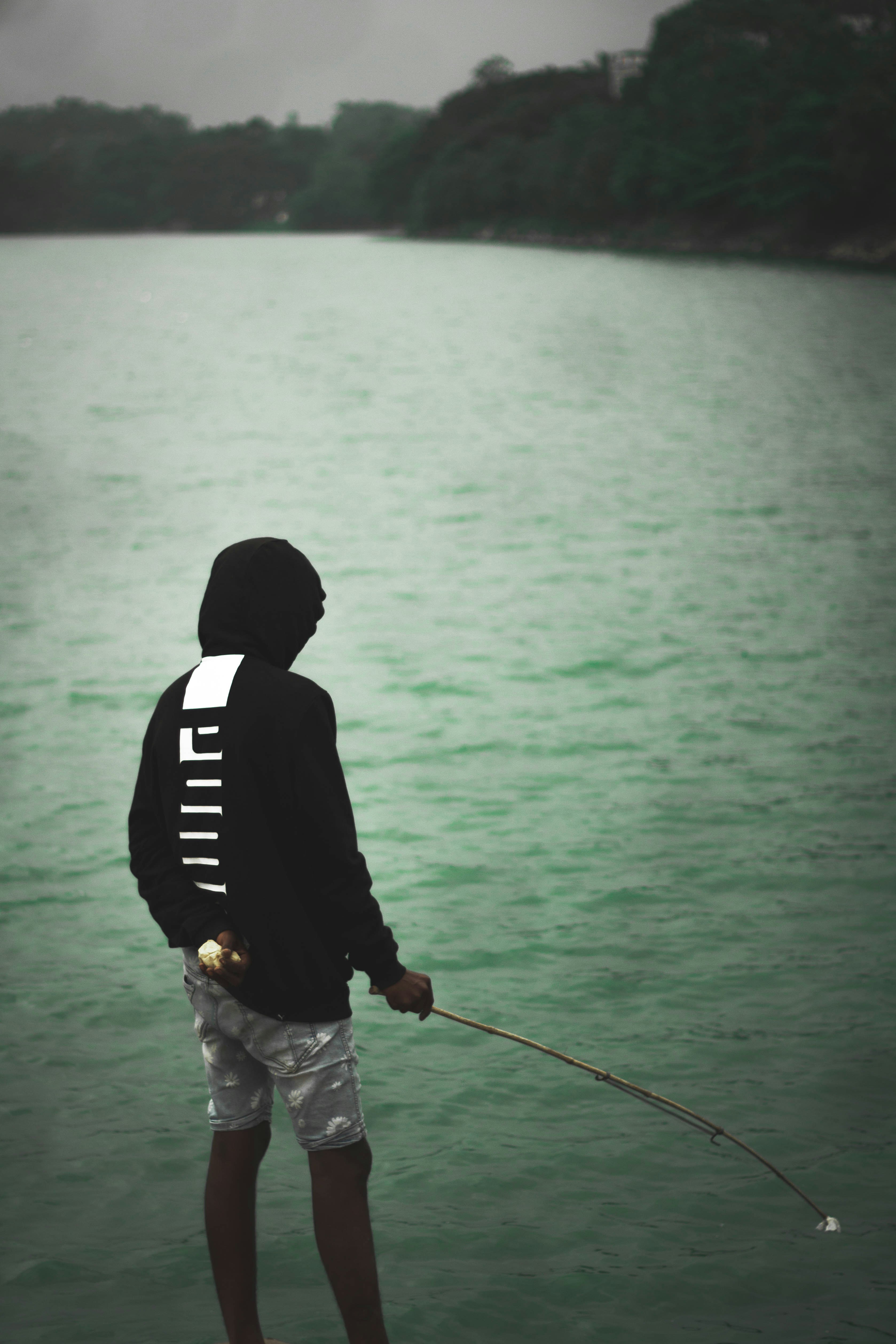 a man standing on a boat holding a fishing pole