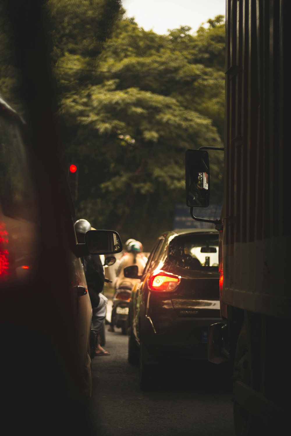 a group of cars driving down a street next to a traffic light