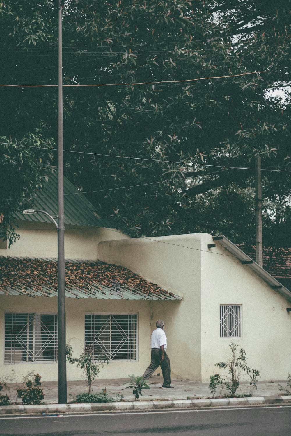 a man walking down the street in front of a house